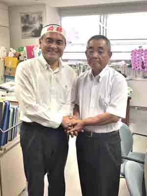 県連事務所で健闘を誓い合う吉田比例区候補（左）と清田委員長