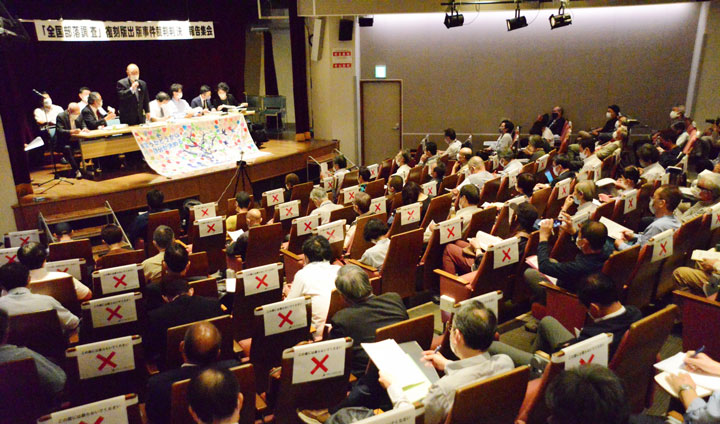 100人が参加した報告集会であいさつする西島書記長（9月27日・東京）