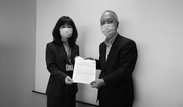 岡田実行委員長が新宅局長（左）に申し入れ書を手渡した（10月18日・広島市）