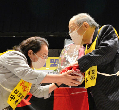 今期で退任した組坂委員長（右）に花束を贈呈。今期で退任した原中執にも花束を贈呈した（6月9日・東京）