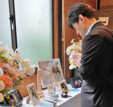 復元された石川一雄さん宅のある狭山闘争勝利現地事務所で、位牌に線香をあげる杉山寿英・連合連帯活動局長（4月11日・埼玉県狭山市）